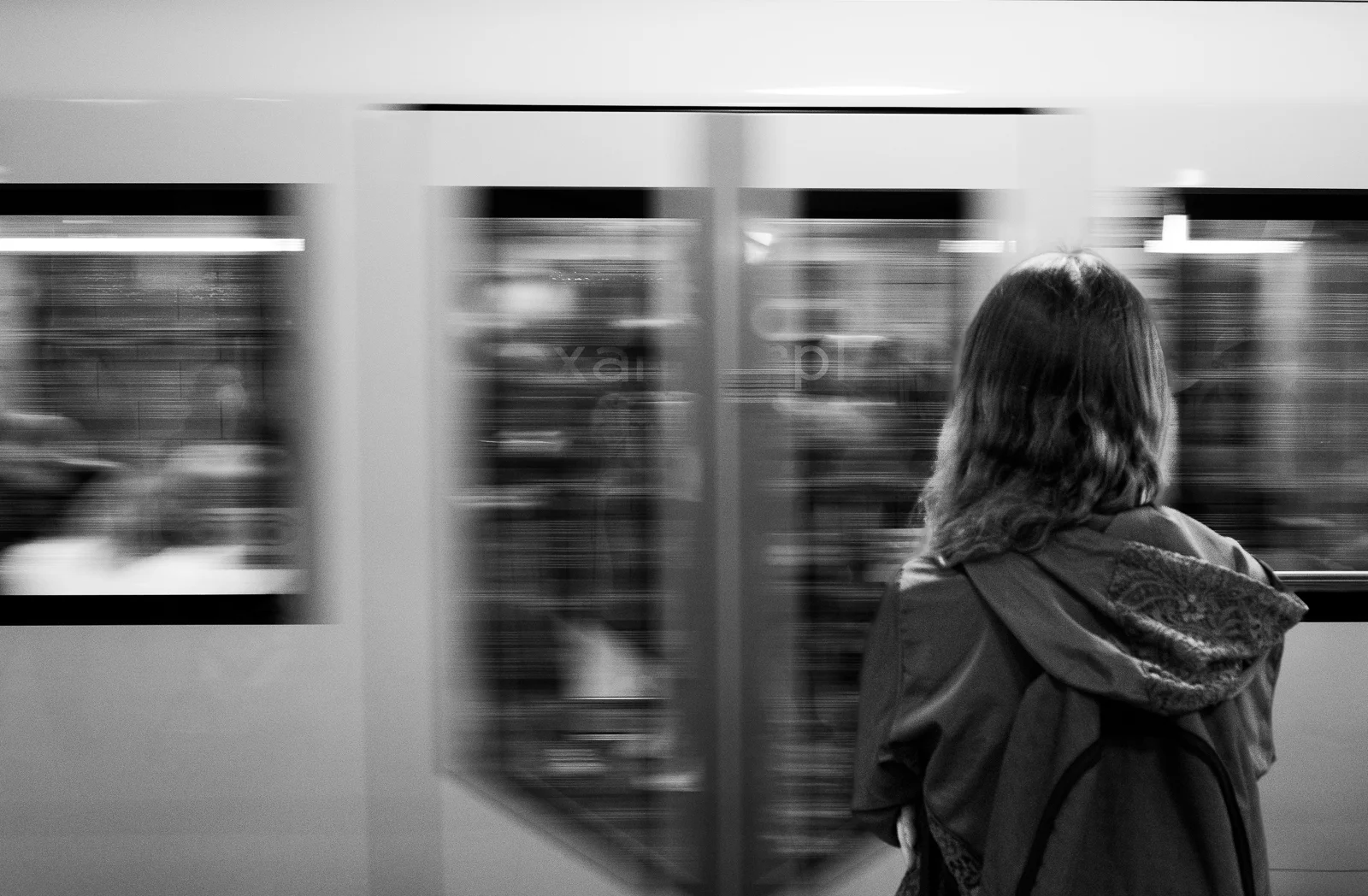 A person watching a train blur past. Photograph by Adelina Persa.