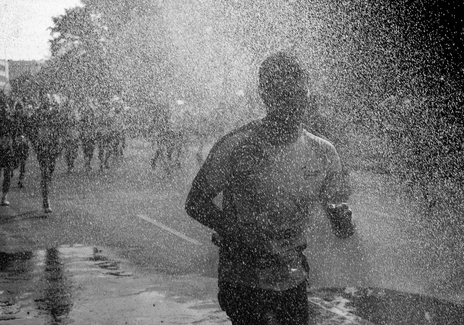 A person running through a cloud of water. Photograph by Adelina Persa.