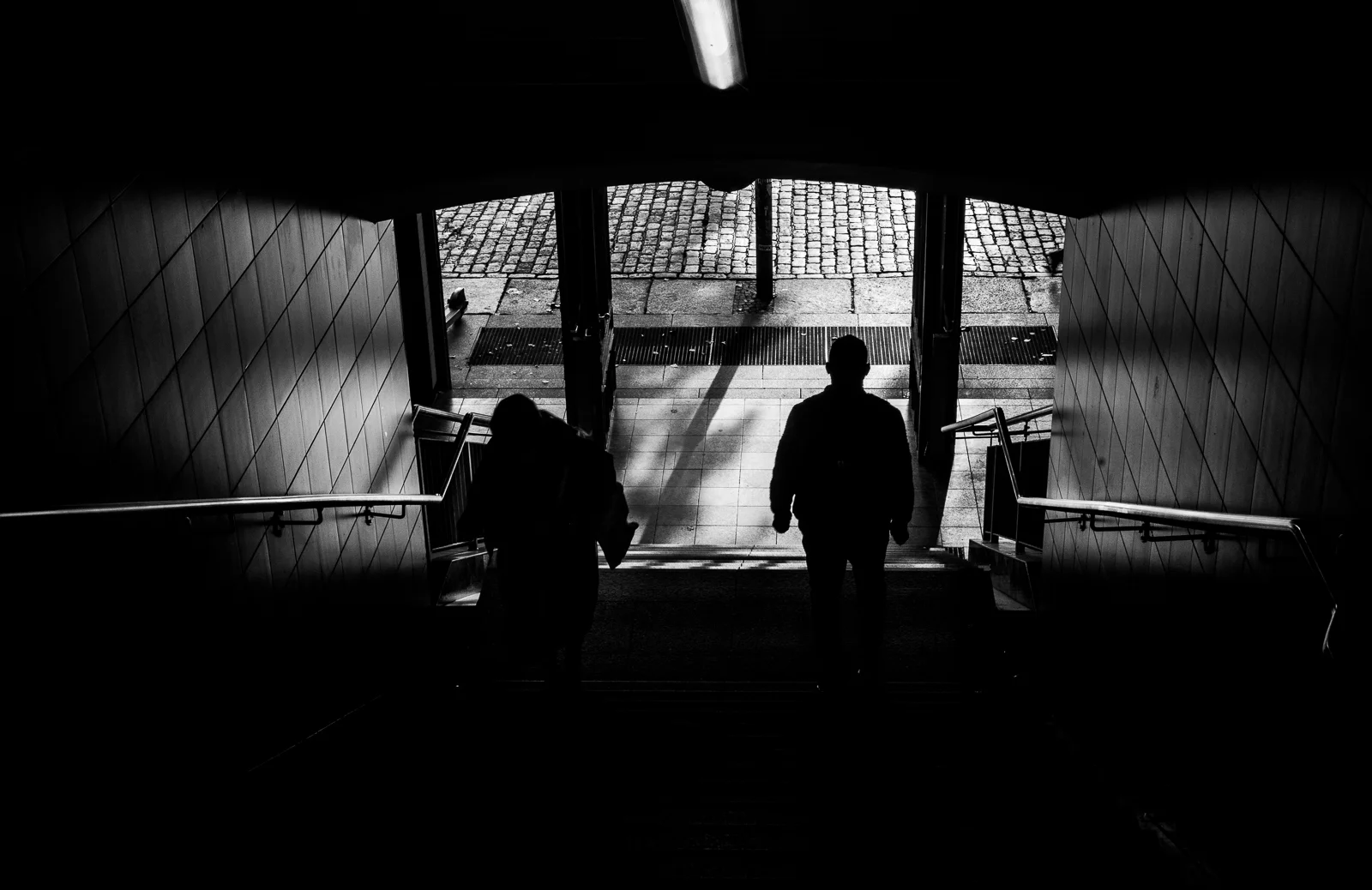 People descending into a passage filled with light. Photograph by Adelina Persa.