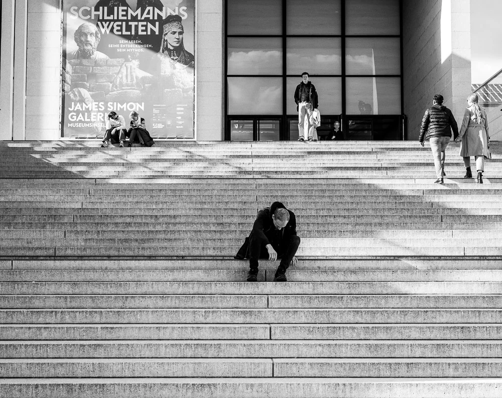 People sitting and walking on broad museum steps. Photograph by Adelina Persa.