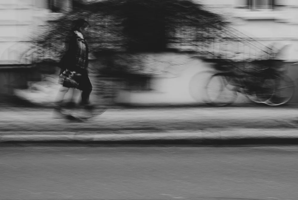 A woman walking past in motion blur. Photograph by Adelina Persa.